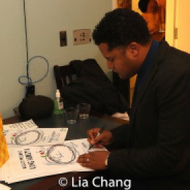 Brandon J. Dirden signs posters. Photo by Lia Chang